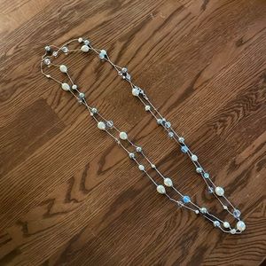 Long beaded necklace with grey, white, and clear crystals
